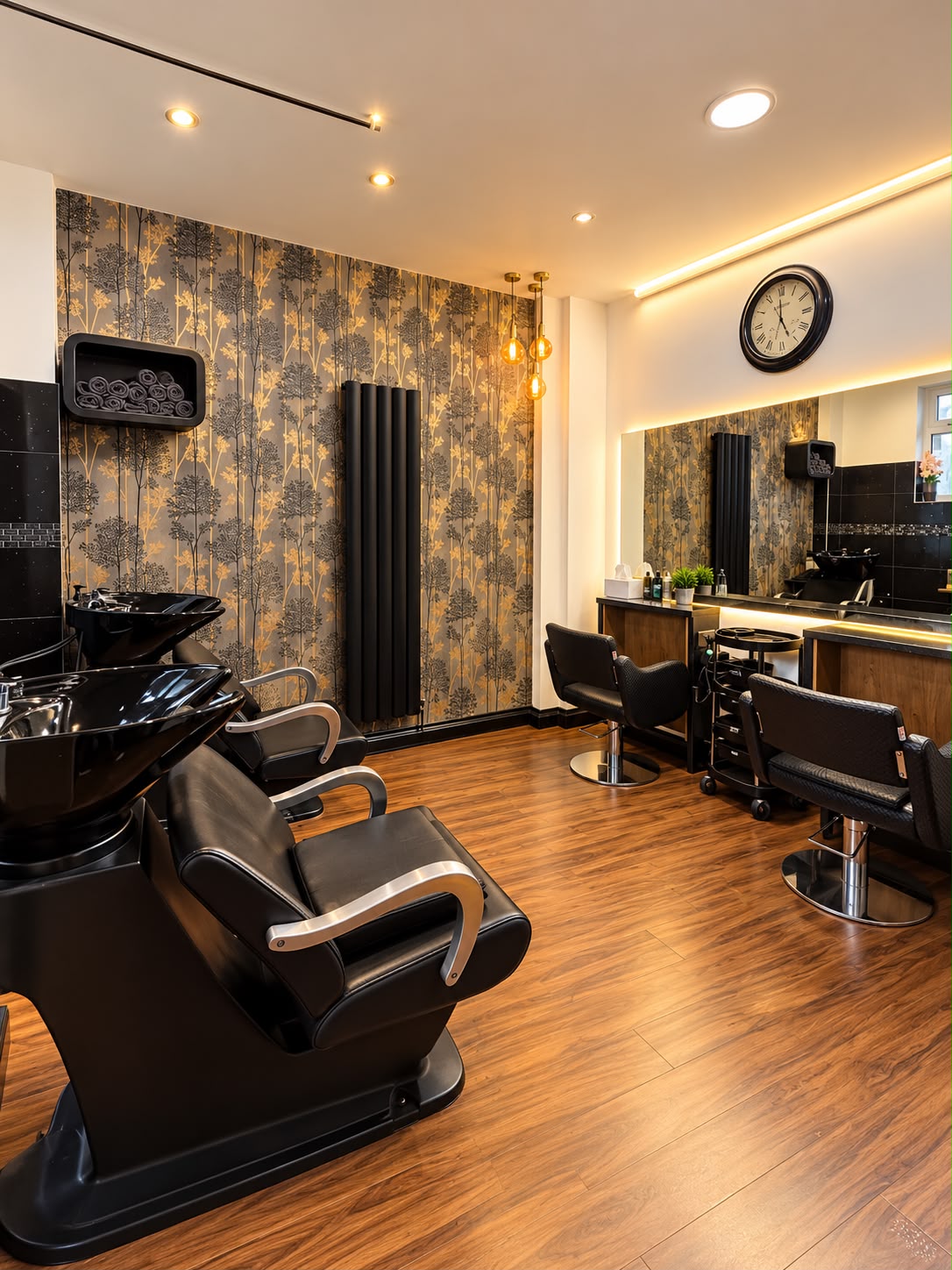 The backwash area with black basins, reclining chairs and botanical wallpaper