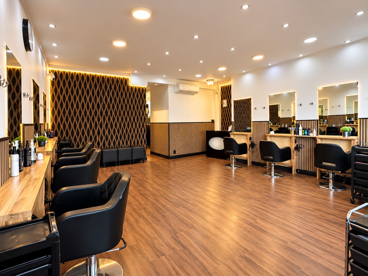 The main salon floor: walnut wave panels, warm LED lighting and black styling chairs